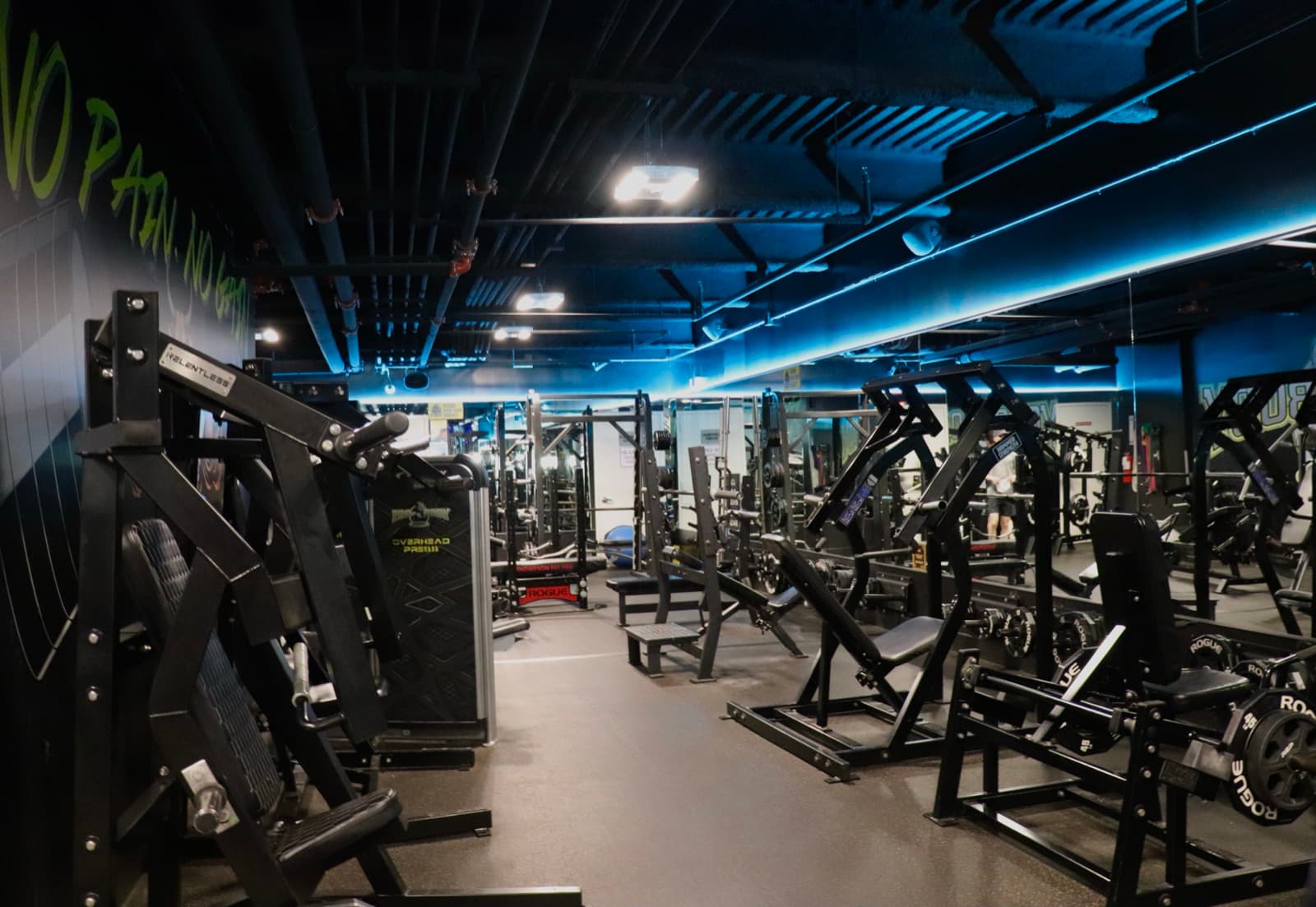 The main training floor at ProBody Fitness, stretching back under coloured LED lighting