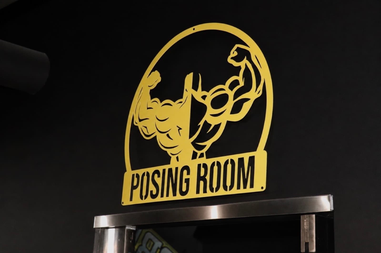 The gold Posing Room sign at ProBody Fitness